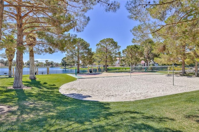 surrounding community with a yard, a water view, and volleyball court