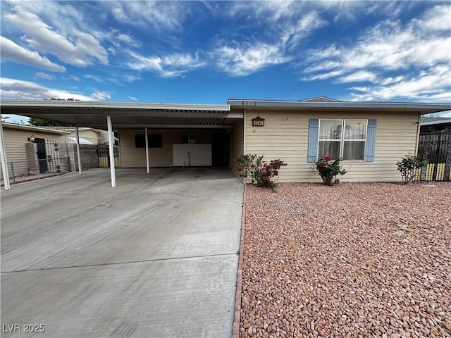 ranch-style house with driveway, an attached carport, and fence