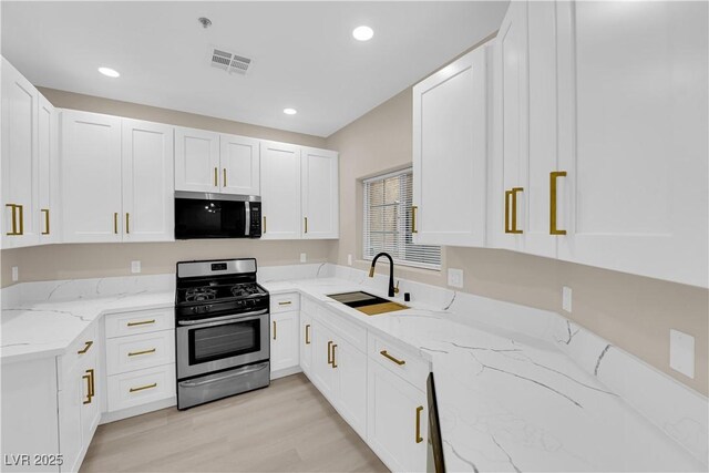 2007 Cutlass Dr Unit 0, Henderson, NV 89014 - kitchen featuring light stone countertops, appliances with stainless steel finishes, a sink, light wood finished floors, and white cabinetry