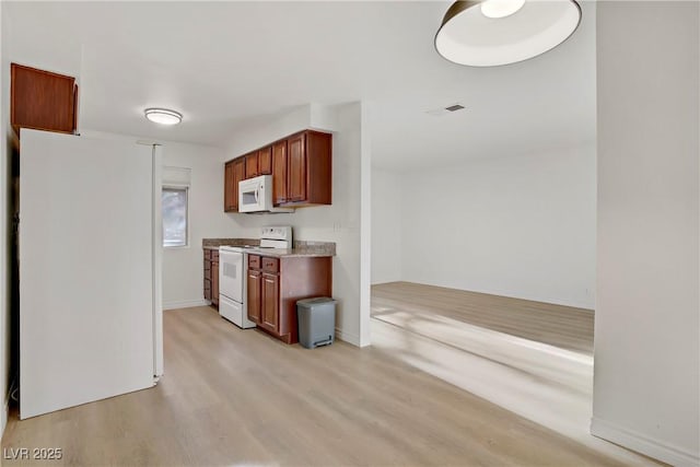 kitchen featuring baseboards, light wood finished floors, white appliances, and visible vents