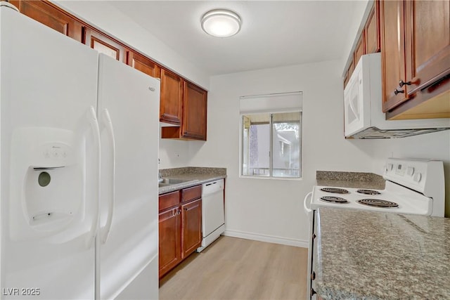 kitchen with light wood-style floors, baseboards, and white appliances