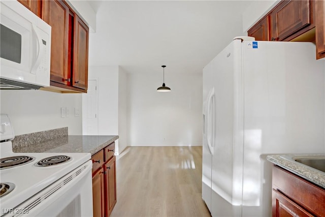 kitchen featuring white appliances, baseboards, reddish brown cabinets, light wood-style flooring, and decorative light fixtures
