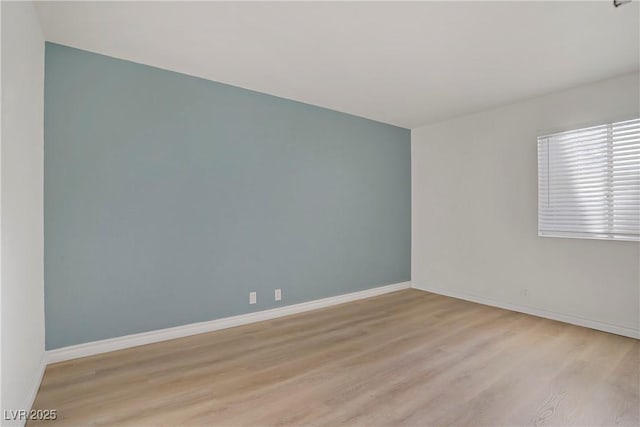 empty room with light wood-style floors and baseboards