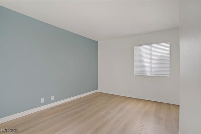 empty room with baseboards and wood finished floors