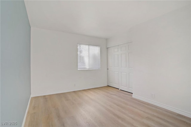 unfurnished room with baseboards and wood finished floors