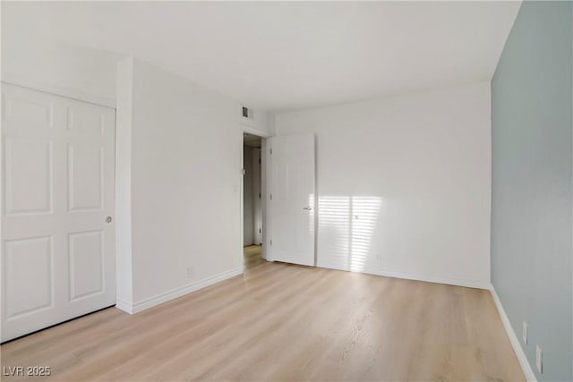 unfurnished bedroom featuring baseboards, visible vents, and light wood-style flooring