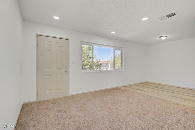 spare room featuring recessed lighting, visible vents, and carpet