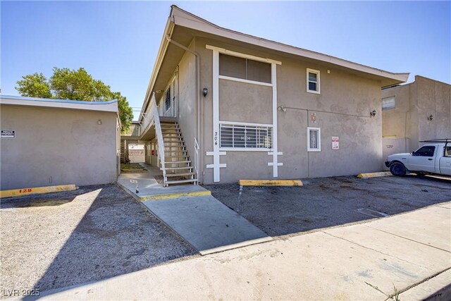 view of property exterior with stairway and stucco siding