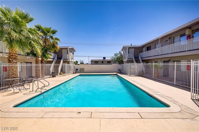 community pool featuring fence and a patio area