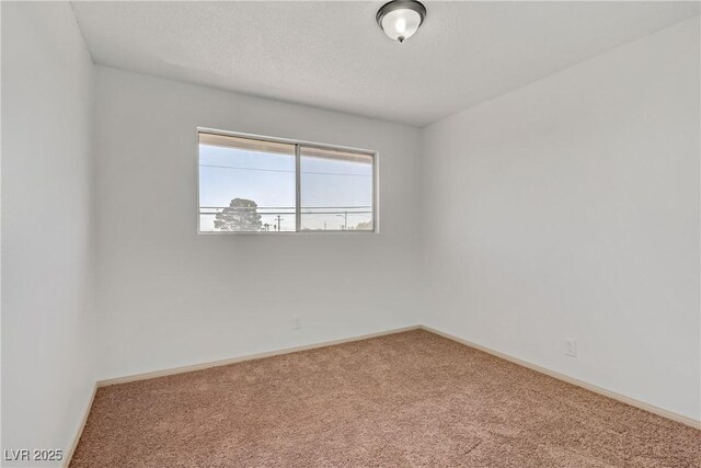 empty room featuring baseboards and carpet