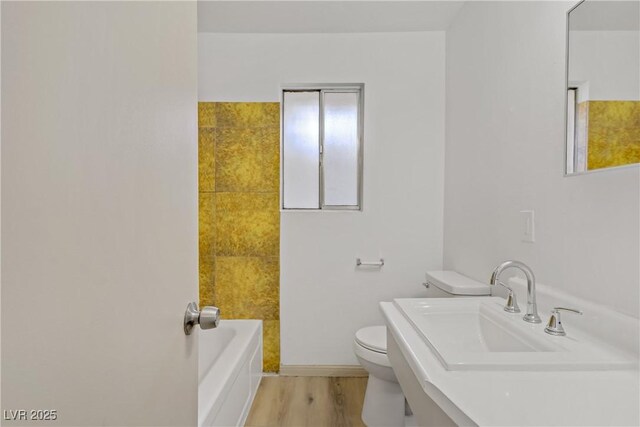 full bathroom with baseboards, toilet, and wood finished floors