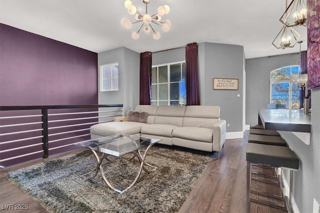 living area featuring baseboards, a chandelier, and wood finished floors