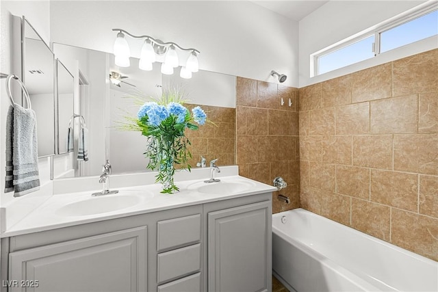 full bath with double vanity, a sink, and tub / shower combination