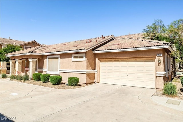 ranch-style home with an attached garage, stucco siding, driveway, and a tiled roof