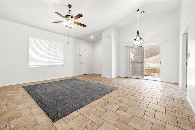 empty room featuring a ceiling fan, baseboards, and lofted ceiling