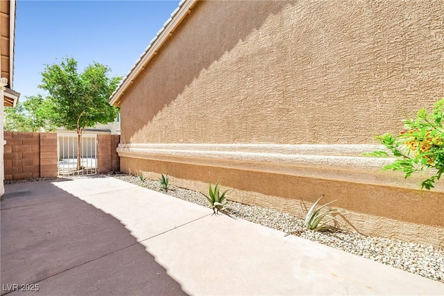 view of property exterior featuring fence, stucco siding, and a patio area