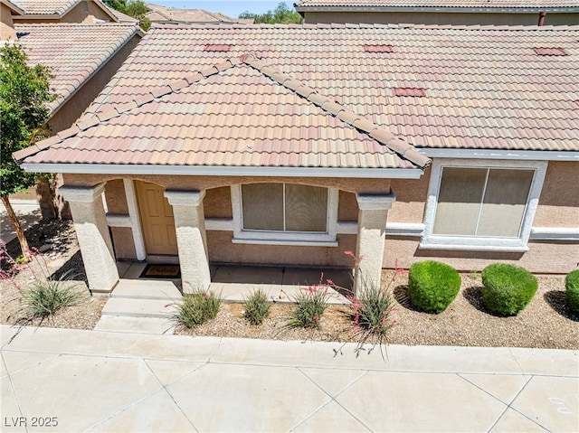 view of front of home with a tiled roof and stucco siding
