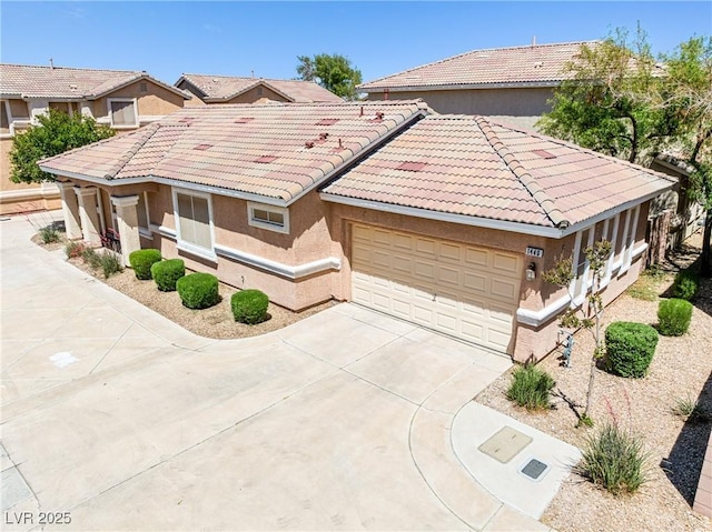 view of front facade featuring a garage, stucco siding, driveway, and a tile roof