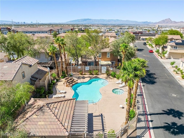 pool featuring a mountain view, fence, and a residential view