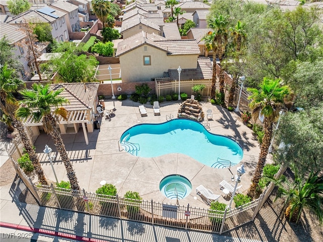 community pool with a fenced backyard, a community hot tub, a patio area, and a residential view