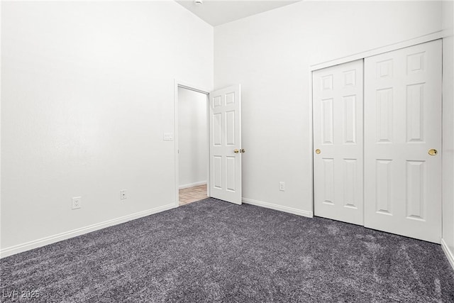 unfurnished bedroom featuring carpet floors, baseboards, and a closet