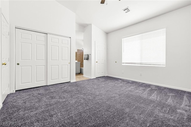 unfurnished bedroom featuring ceiling fan, visible vents, vaulted ceiling, carpet floors, and baseboards