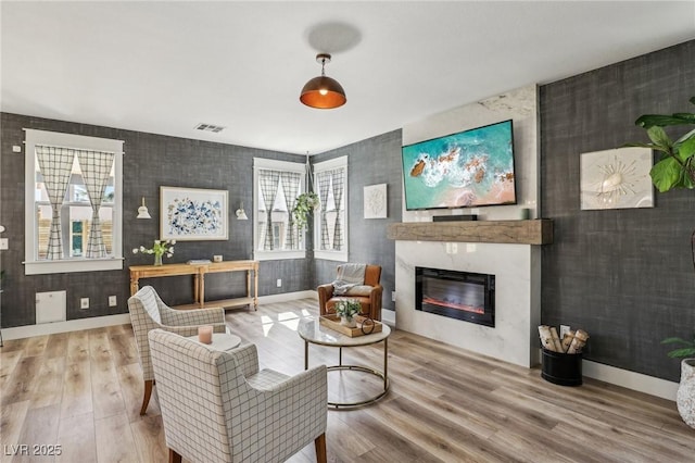 7566 Hope Valley St, Las Vegas, NV 89139 - living room featuring a large fireplace, baseboards, wood finished floors, and visible vents