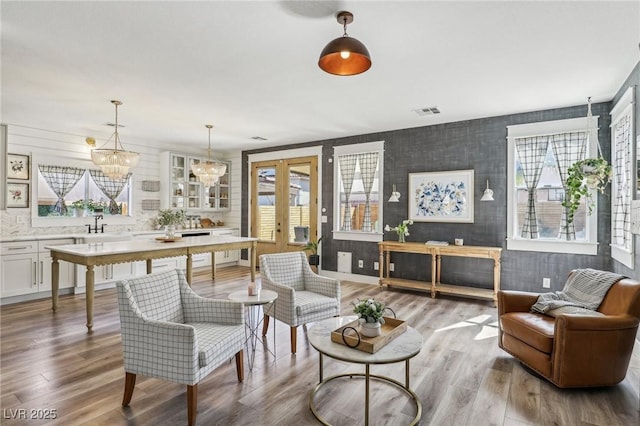 7566 Hope Valley St, Las Vegas, NV 89139 - living area with visible vents, wood finished floors, french doors, and an inviting chandelier