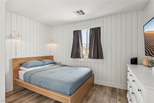 7566 Hope Valley St, Las Vegas, NV 89139 - bedroom with wooden walls, baseboards, wood finished floors, and visible vents