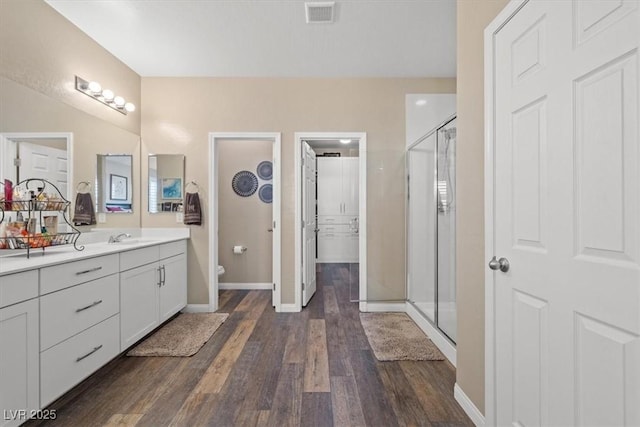 bathroom with visible vents, a stall shower, wood finished floors, vanity, and baseboards