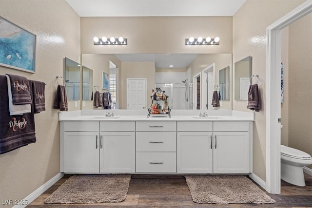 full bath with baseboards, wood finished floors, toilet, and a shower stall