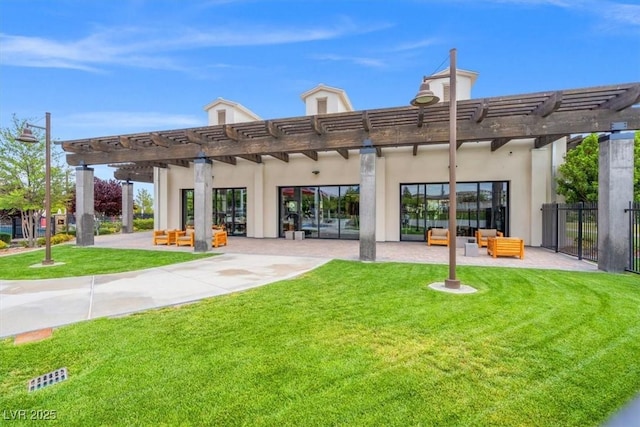 rear view of property with fence, a pergola, stucco siding, and a yard