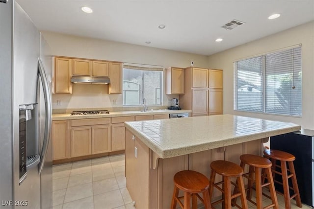 kitchen featuring light brown cabinets, stainless steel appliances, and visible vents