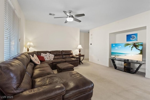 carpeted living room featuring a ceiling fan and visible vents