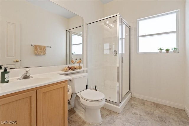 bathroom featuring vanity, a stall shower, toilet, and a wealth of natural light