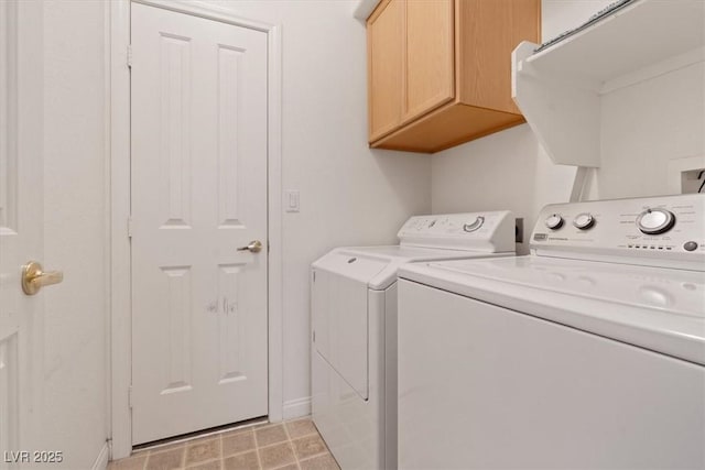 clothes washing area with baseboards, independent washer and dryer, and cabinet space