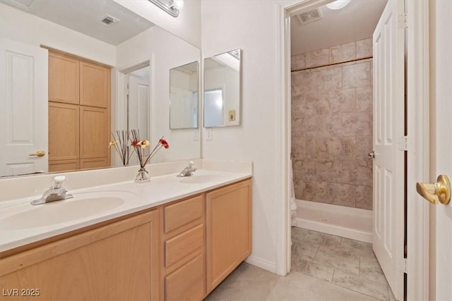 full bathroom featuring double vanity, a sink, tile patterned flooring, and a shower stall