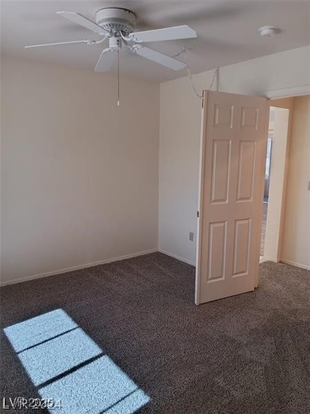 carpeted empty room featuring baseboards and ceiling fan