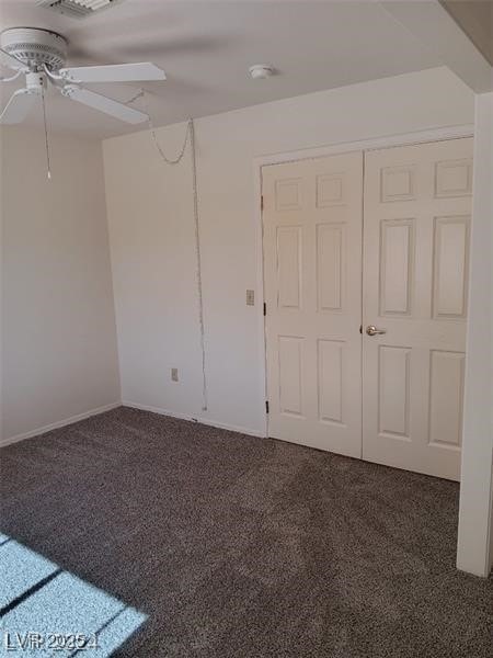 empty room with carpet flooring, a ceiling fan, and visible vents