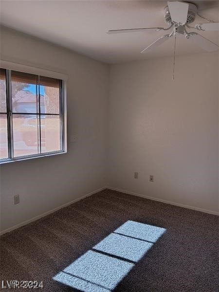 spare room featuring baseboards, ceiling fan, and carpet
