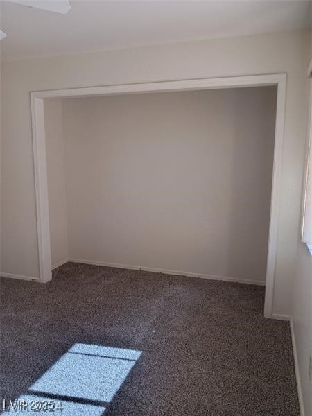 empty room with baseboards and carpet