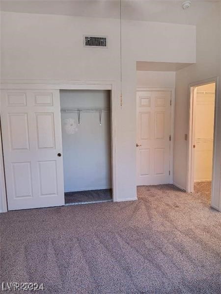 unfurnished bedroom featuring baseboards, visible vents, carpet, and a closet