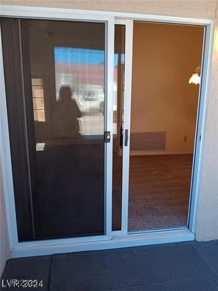 entrance to property featuring stucco siding