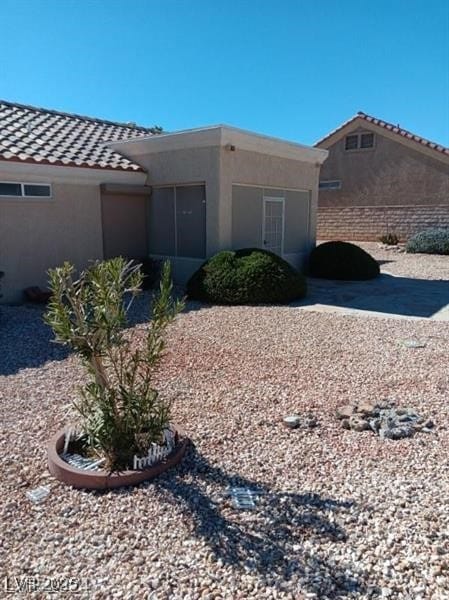 view of home's exterior featuring stucco siding and a tile roof