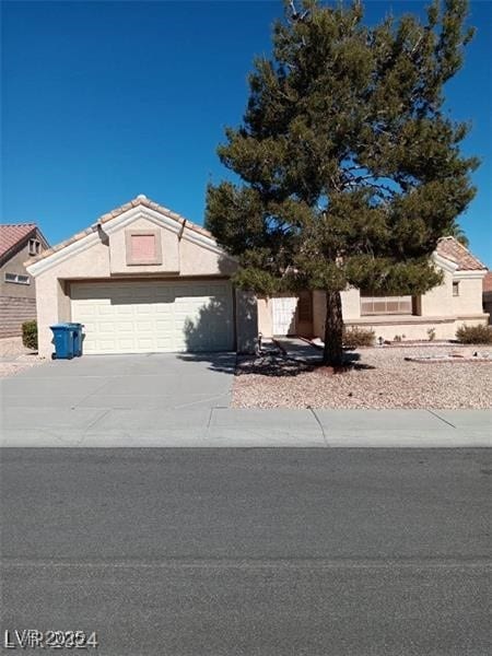 view of front of home with an attached garage, stucco siding, and driveway