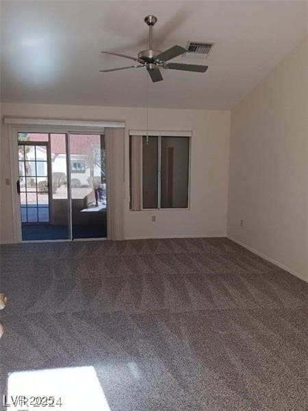 carpeted empty room with visible vents and a ceiling fan