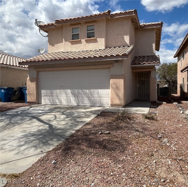mediterranean / spanish home with a garage, stucco siding, a tile roof, and concrete driveway