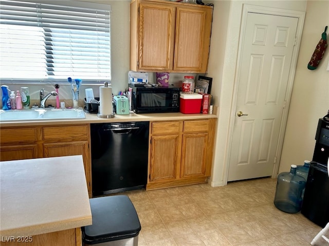 kitchen featuring a sink, light countertops, black appliances, and brown cabinets