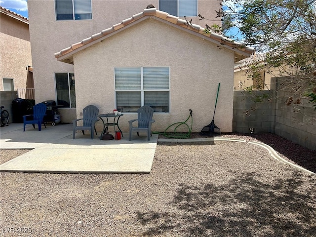 back of property featuring a fenced backyard, a patio area, and stucco siding