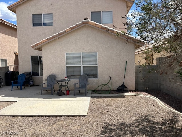 back of house with a patio, a fenced backyard, stucco siding, and a tile roof